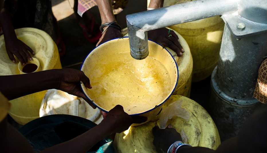 Personas recolectando agua en envases