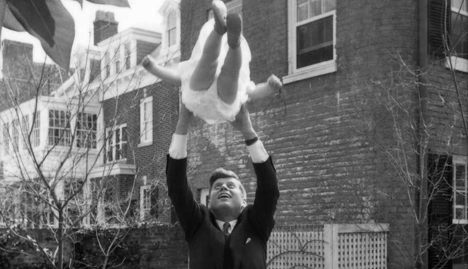 Kennedy y la pequeña Caroline en el aire se ven en el patio trasero de su casa 