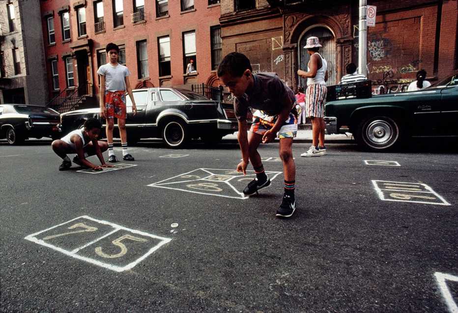 Niños jujando skelly en una calle