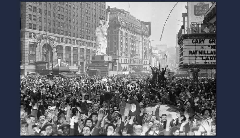 Foto muestra a una gran multitud de personas jubilosas que se reúnen en una calle de la ciudad de Nueva York 