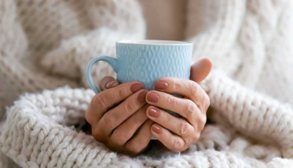 Unas manos de una mujer sosteniendo una taza.