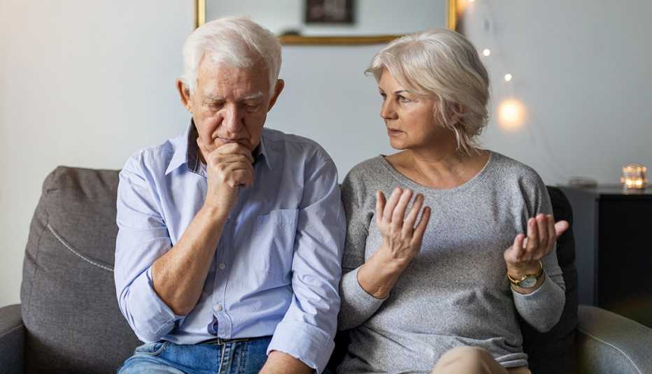 Una pareja casada sentada en el sofá teniendo un desacuerdo Una pareja casada sentada en el sofá teniendo un desacuerdo