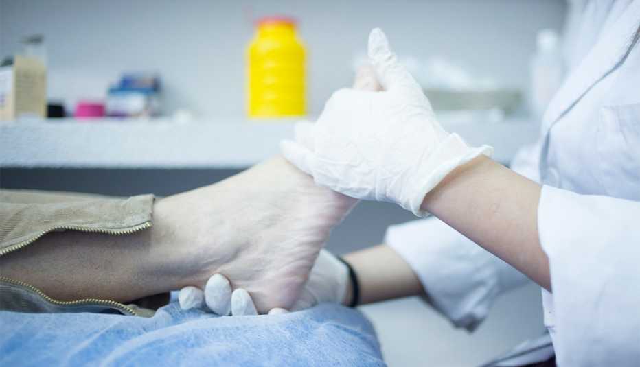 Consejos para el cuidado de los pies - Médico masajea el pie de una persona