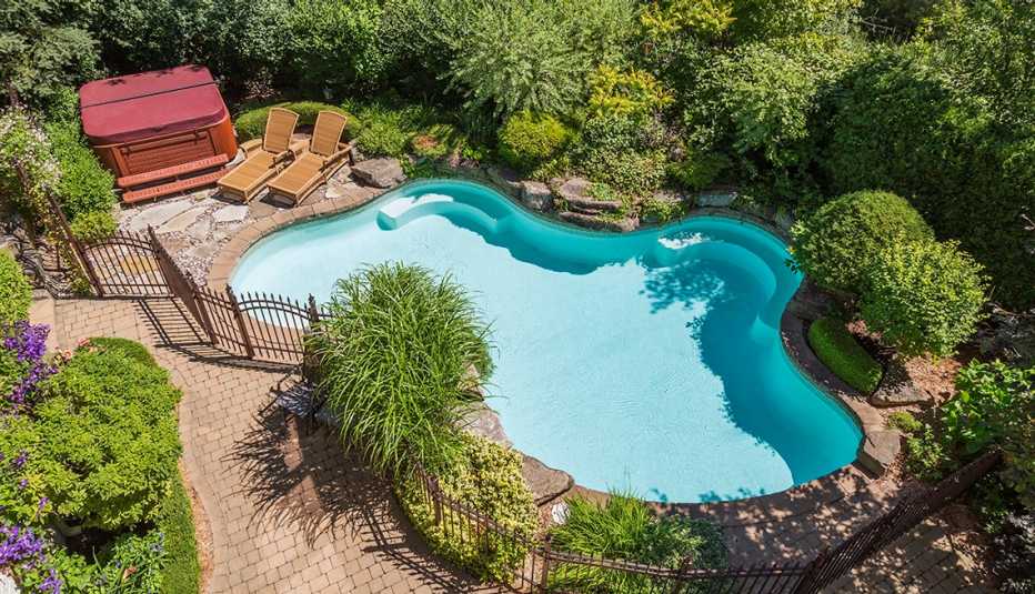 An in-ground swimming pool with a fence around it