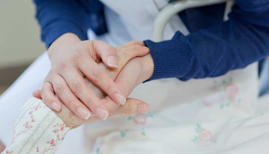 Una mujer sostiene las manos de su madre Una mujer sostiene las manos de su madre