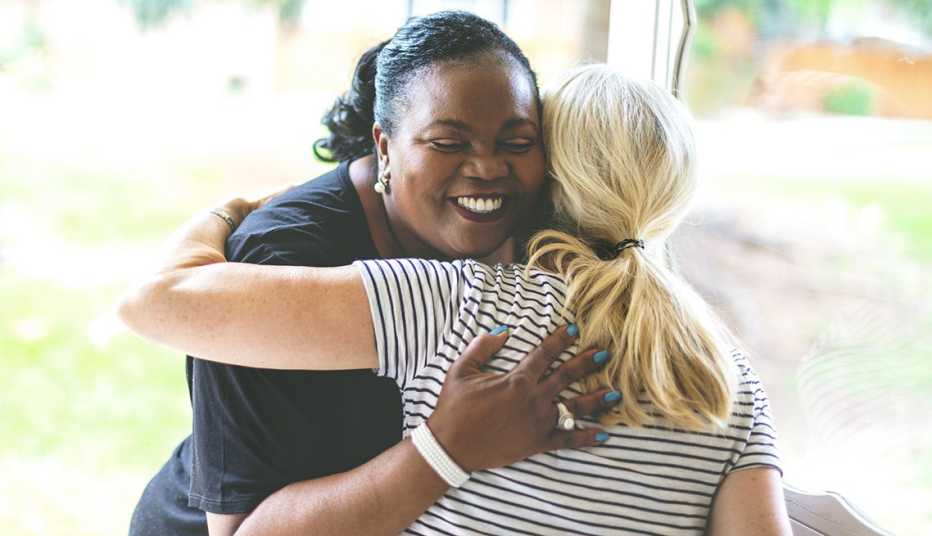 Dos mujeres se abrazan en un saludo