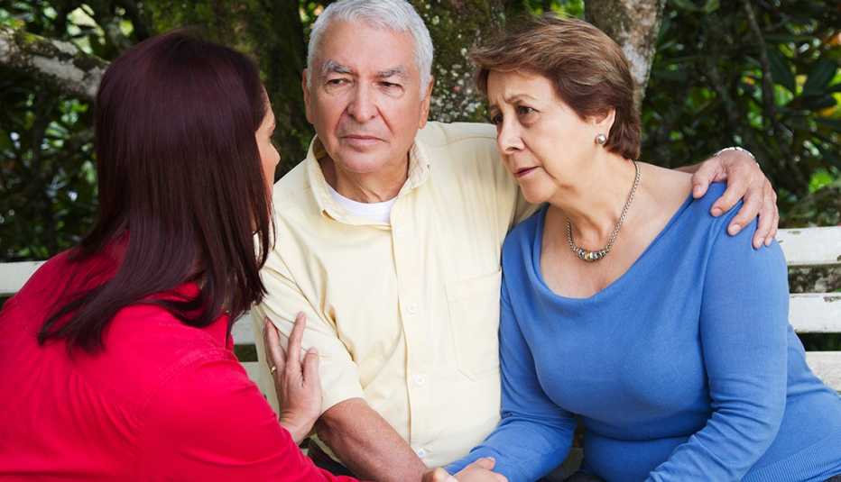 Una hija adulta habla seriamente con sus padres mayores.