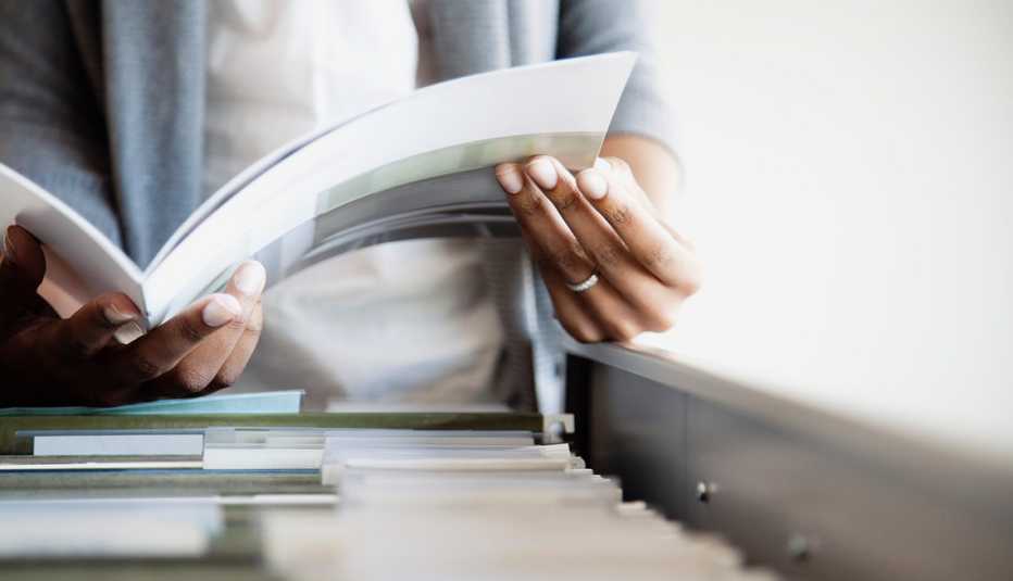 Cómo organizar documentos importantes — Una persona sostiene un documento en sus manos.