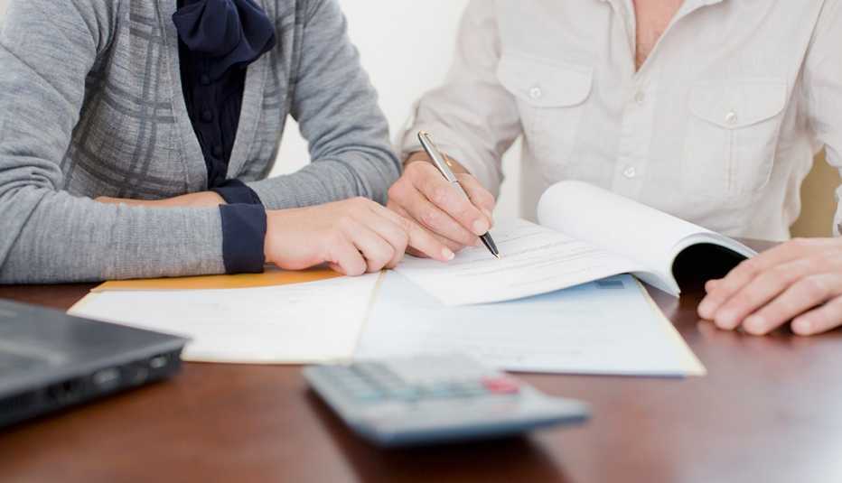Personas firmando unos documentos
