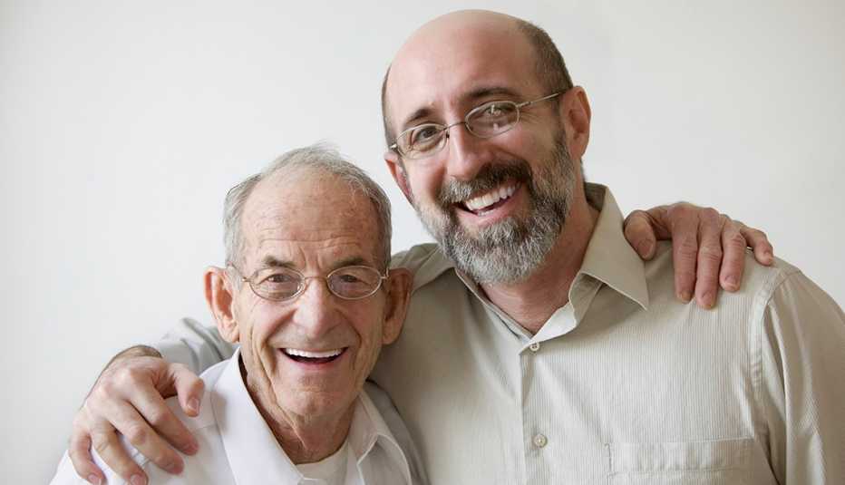 Padre e hijo abrazados sonríen a la cámara.