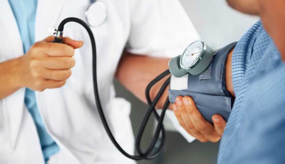 Enfermera tomando la presión arterial a un paciente Enfermera tomando la presión arterial a un paciente