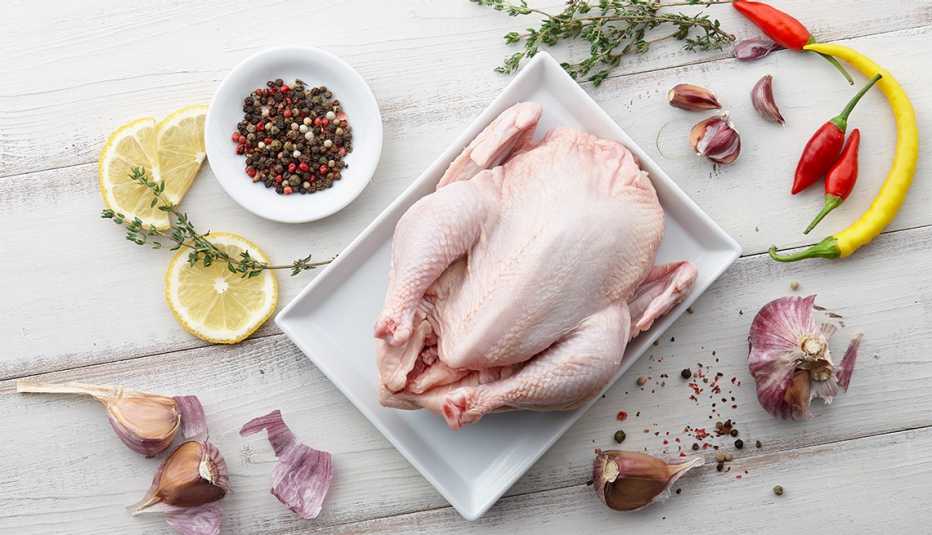 Pollo crudo rodeado de especias. Riesgo de salmonela. Pollo crudo rodeado de especias. Riesgo de salmonela.