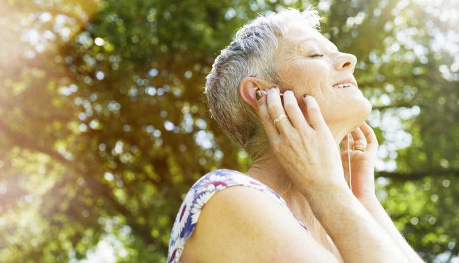 Mujer escuchando música con audífonos - Pérdida auditiva Mujer escuchando música con audífonos - Pérdida auditiva
