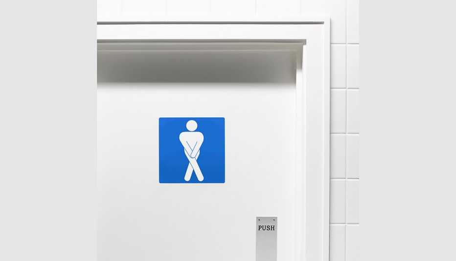 Letrero de baño y figura cruzando las piernas