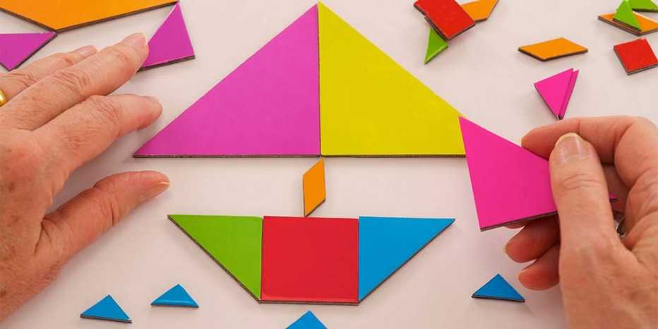 Manos construyendo un rompecabezas de diversas formas y colores