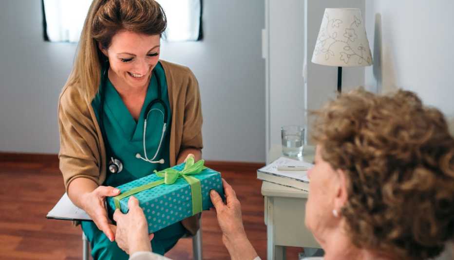 Doctora recibiendo un regalo de un paciente Doctora recibiendo un regalo de un paciente