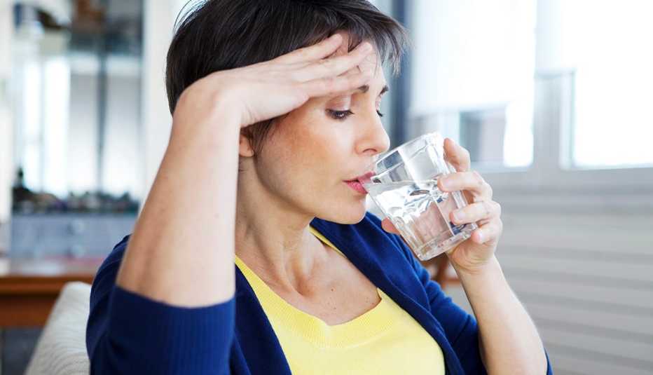 Una mujer toma agua de un vaso