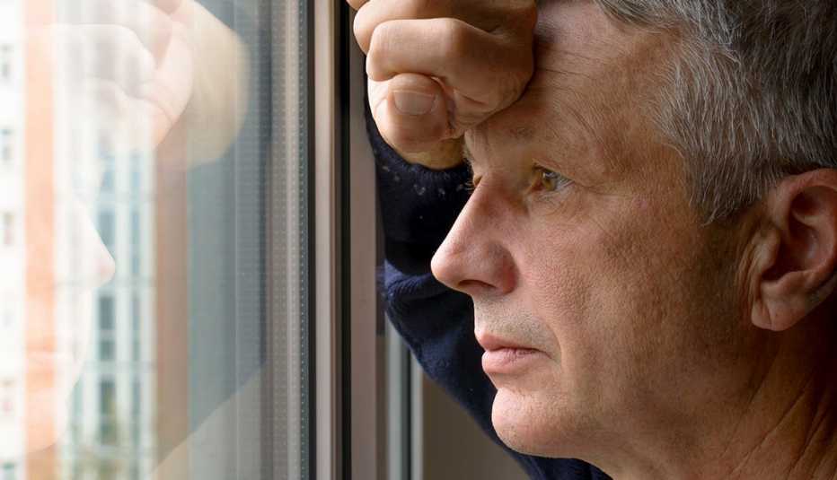 Hombre mira por una ventana