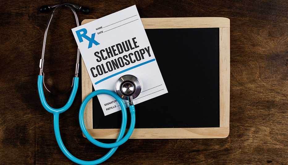 Referido médico para una colonoscopía, un estetoscopio y una pizarra pequeña
