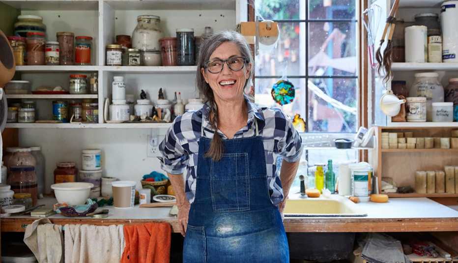 Retrato de mujer mayor con pelo gris dentro de su estudio de cerámica.