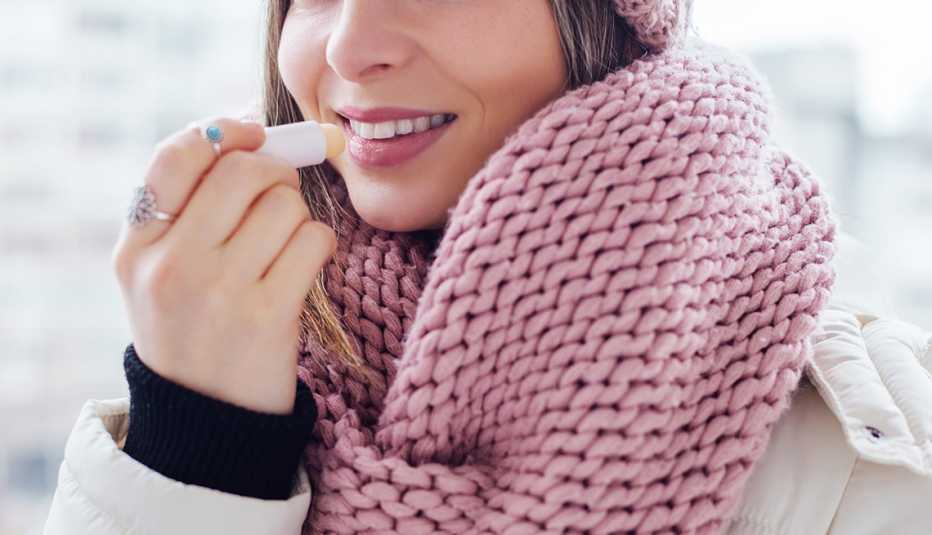 Mujer untándose un bálsamo en los labios