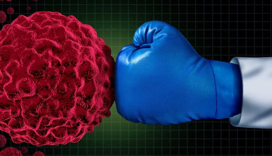 Mano con guante de boxeo golpeando al cáncer