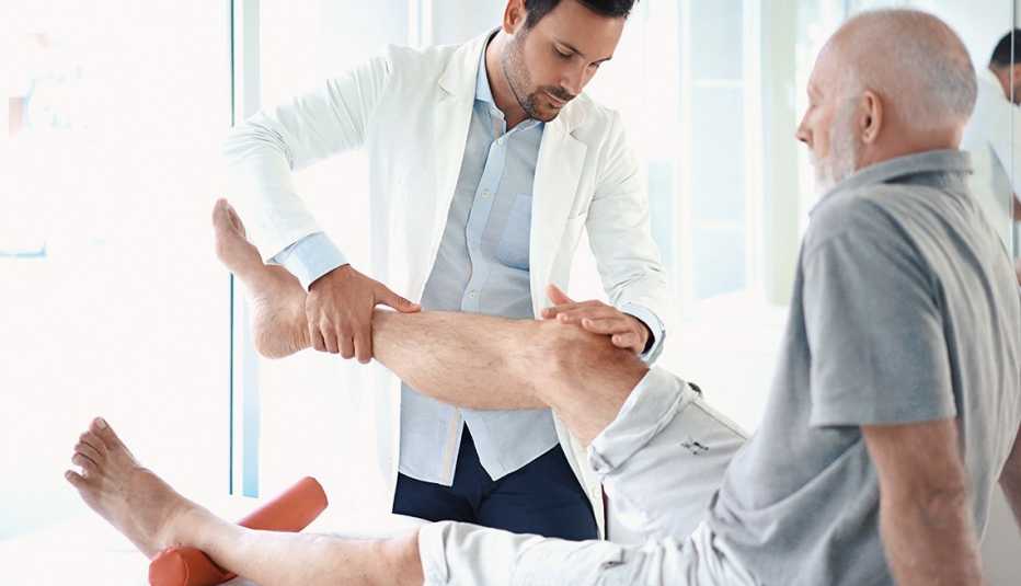 Doctor examina la rodilla de un paciente