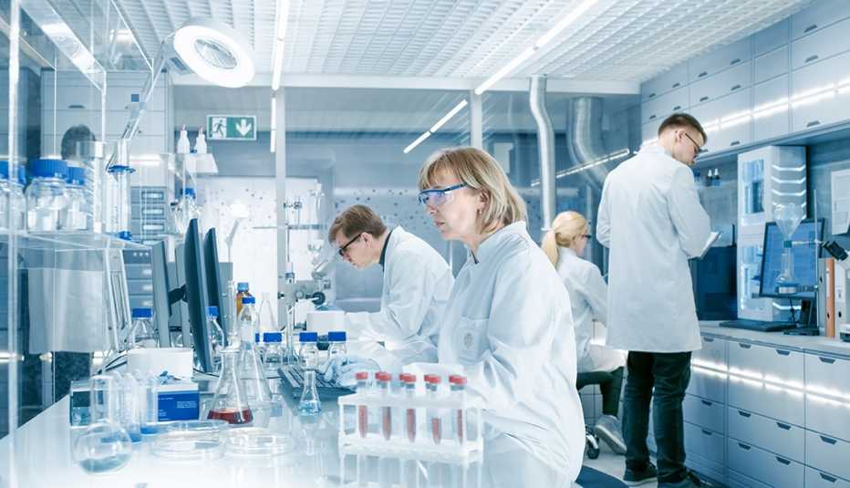 Cuatro científicos trabajan en un laboratorio Cuatro científicos trabajan en un laboratorio