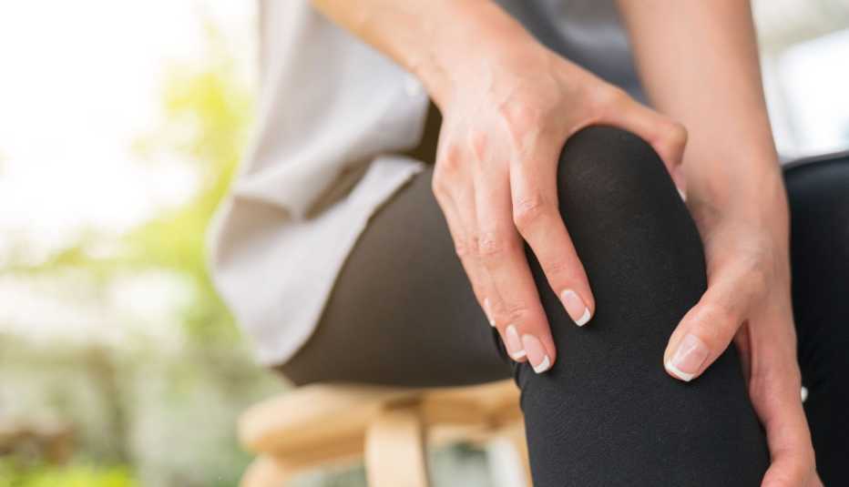 Mujer masajeando su rodilla