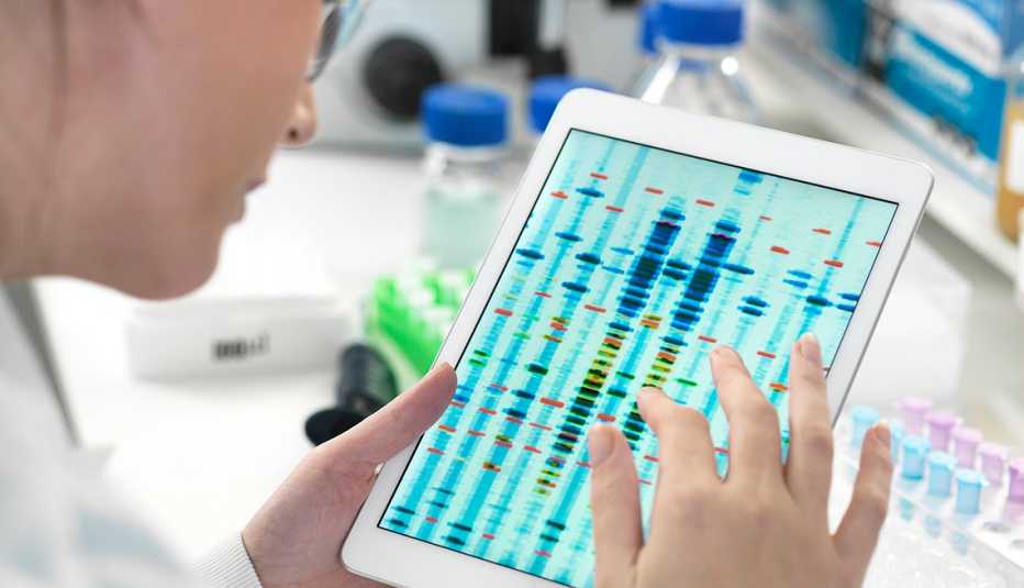 Científica examina la secuencia de ADN en una tableta Científica examina la secuencia de ADN en una tableta