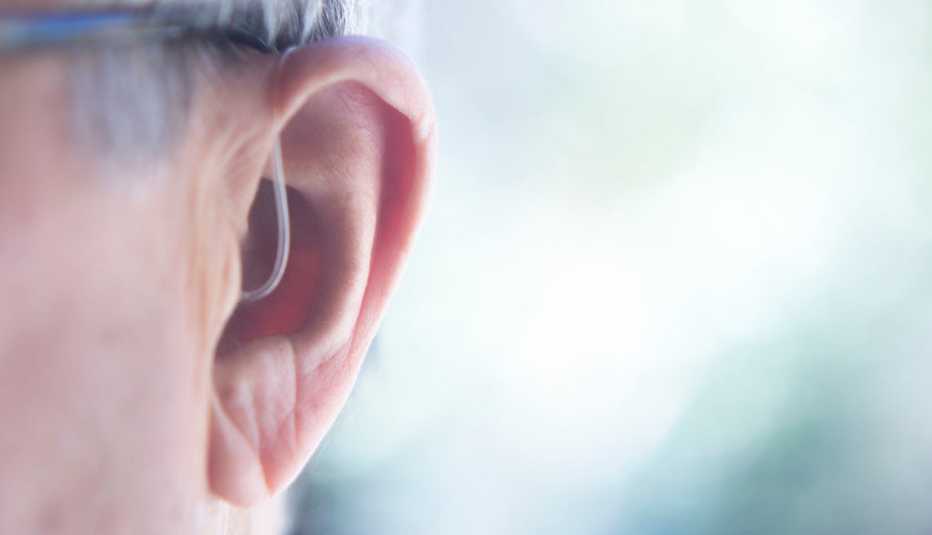 Foto de una oreja usando un audífono apenas perceptible Foto de una oreja usando un audífono apenas perceptible