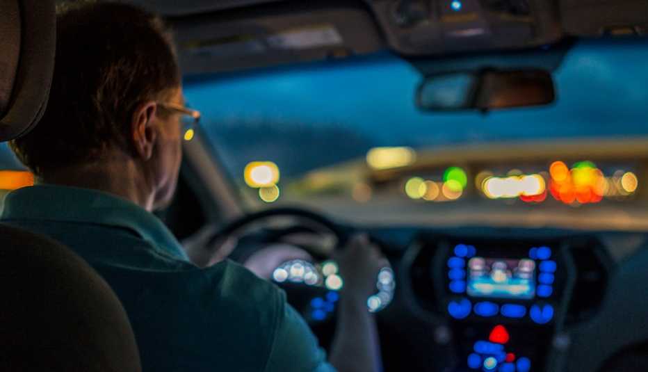 Un hombre manejando su carro en la noche