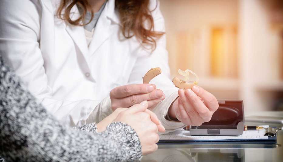 Médico sostiene unos audífonos