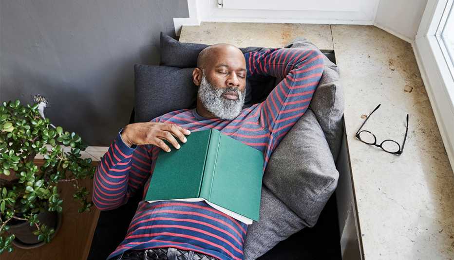 Un hombre toma una siesta en un sofá