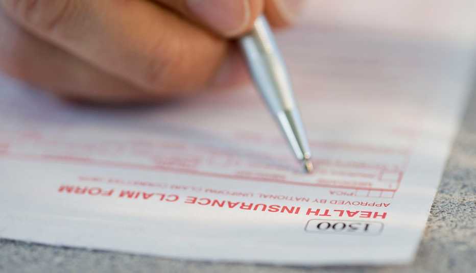Persona llena un documento de una aseguradora médica