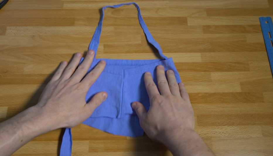Una persona hace una mascarilla con pedazos de una camisa