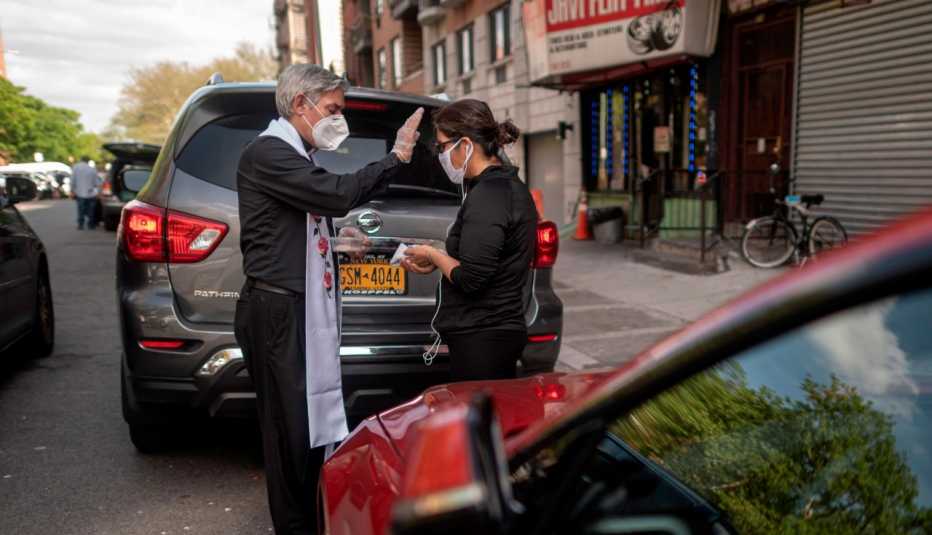 Fabian Arias, un pastor luterano de la Iglesia de San Pedro en Manhattan, entrega la comunión a un miembro de la comunidad