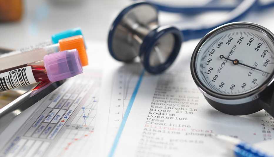 Escritorio de un médico con un estetoscopio, documentos y muestras de sangre