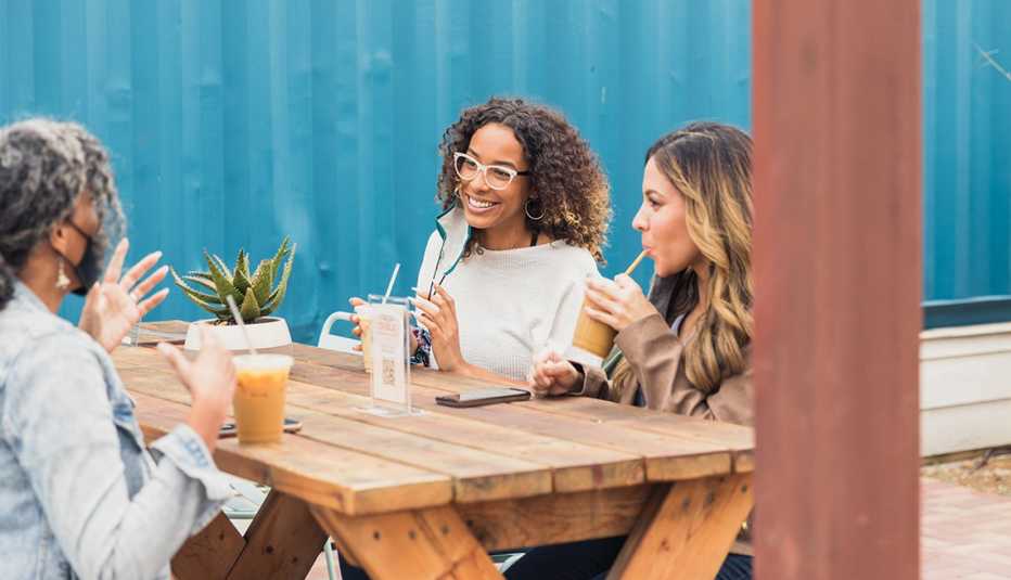 Amistades conversan en una mesa mientras toman un café