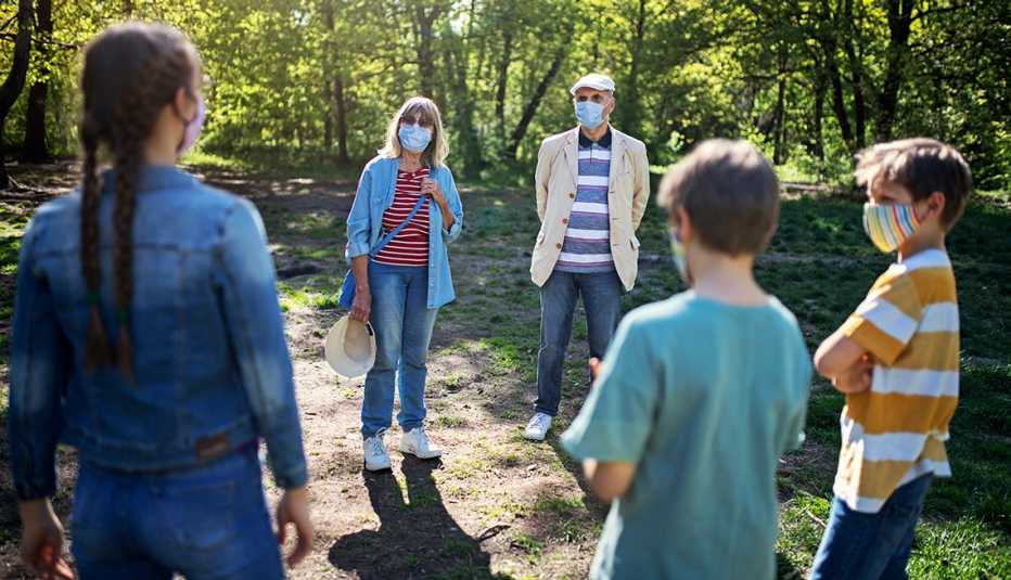 Familia al aire libre usando mascarillas