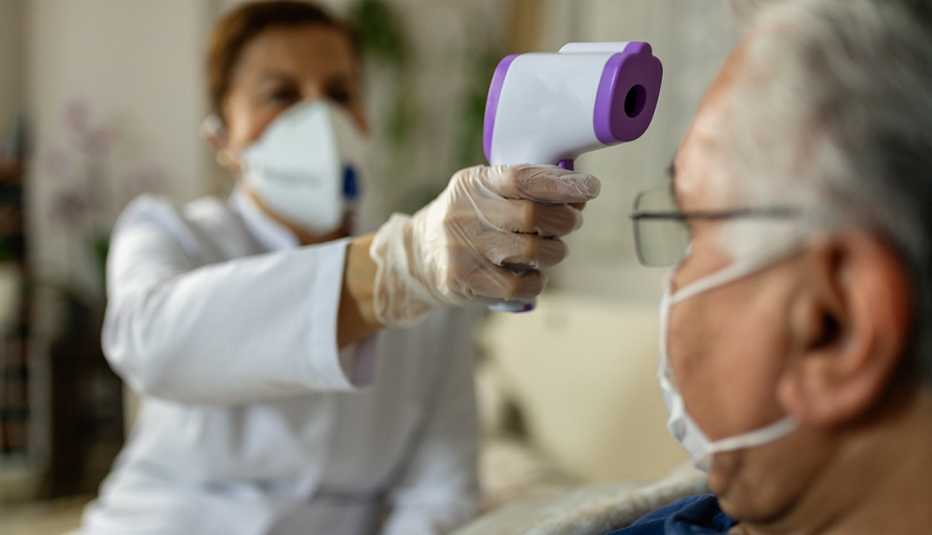 Un médico le toma la temperatura a un paciente