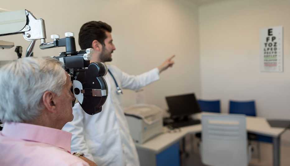 Médico le hace un examen de la vista a un paciente