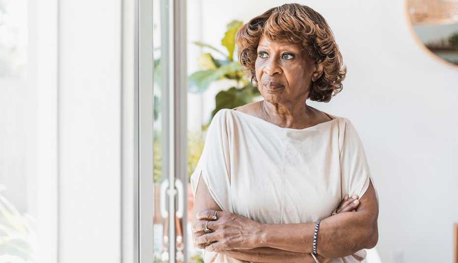 Una mujer afroamericana mira por una ventana