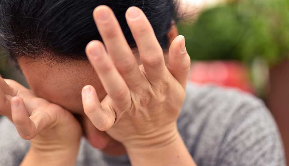 Una mujer se frota los ojos con ambas manos