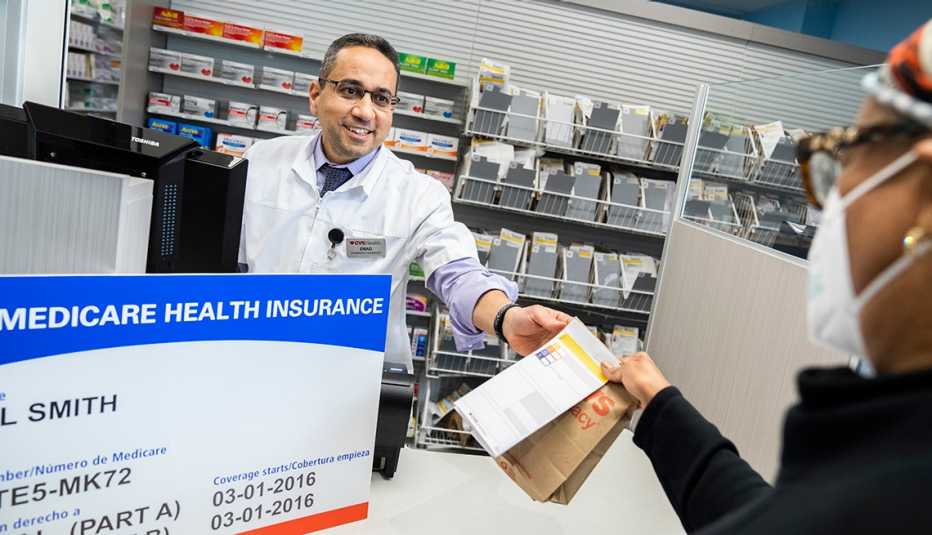 Un farmacéutico despacha un medicamento a un cliente.