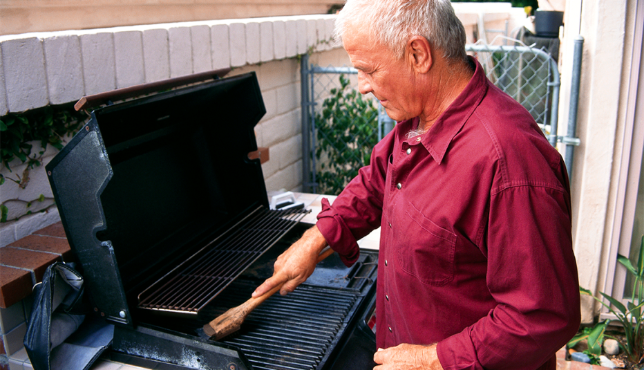 Hombre mayor limpiando la parrilla