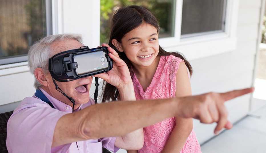Un hombre usa un dispositivo de IrisVision, mientras una niña lo observa Un hombre usa un dispositivo de IrisVision, mientras una niña lo observa