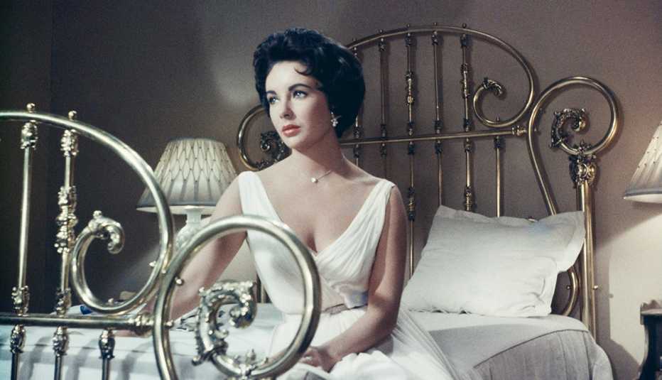 La actris Elizabeth Taylor sentada en una cama mientras filmaba la película  'Cat On A Hot Tin Roof', 1958
