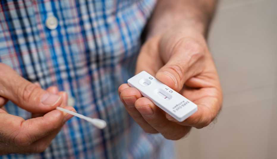 Un hombre sostiene una prueba de COVID