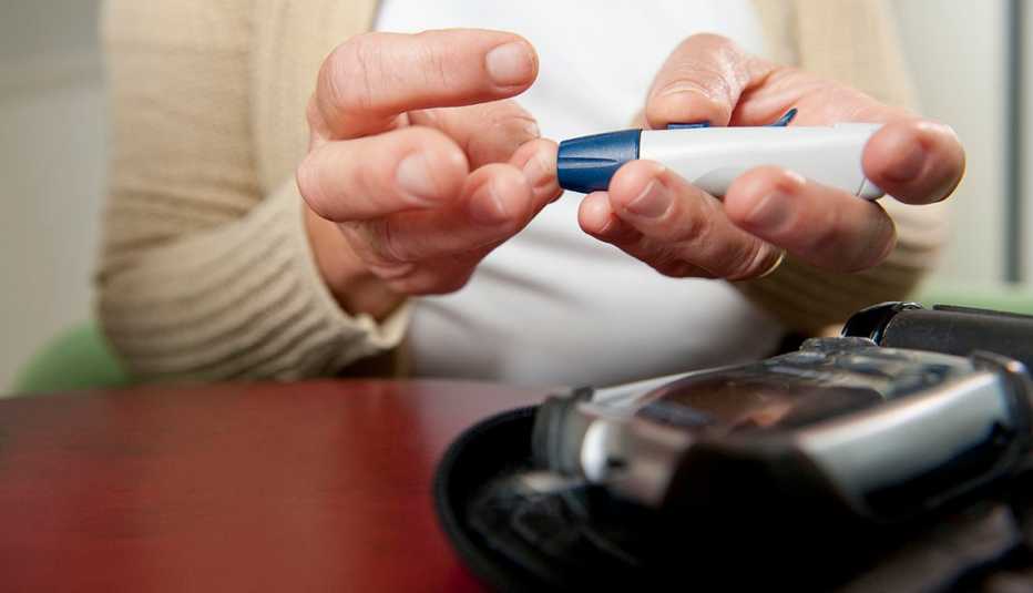 Una mujer utiliza un glucómetro